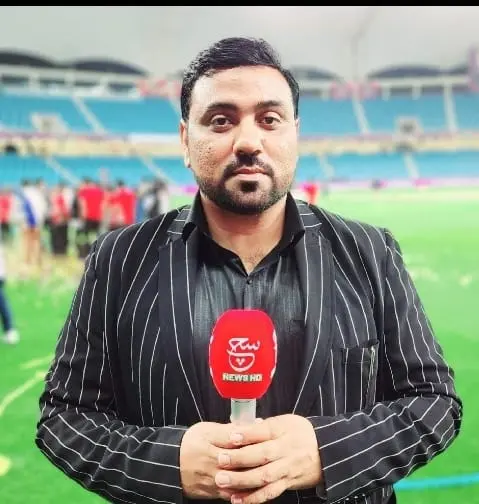 Gulf Media television reporter presenting from a cricket stadium